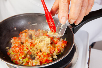 Preparation of the traditional Colombian hogao or criollo sauce (salsa criolla) made of onion, tomato, peppers and cilantro