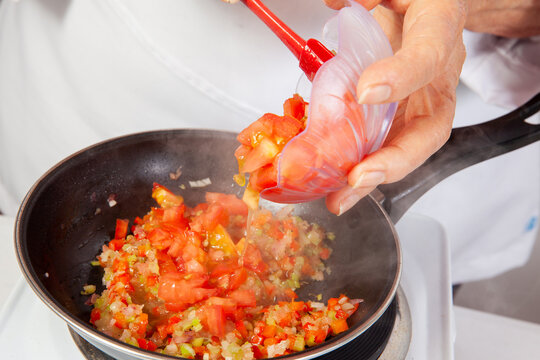 Preparation of the traditional Colombian hogao or criollo sauce (salsa criolla) made of onion, tomato, peppers and cilantro
