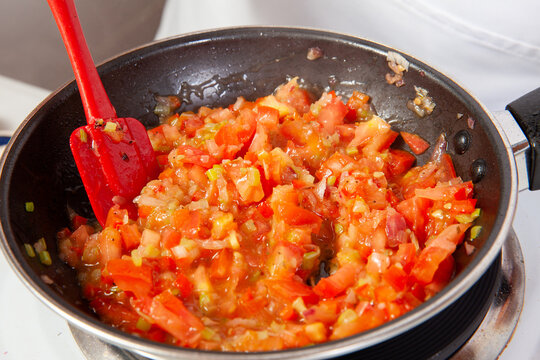 Preparation of the traditional Colombian hogao or criollo sauce (salsa criolla) made of onion, tomato, peppers and cilantro