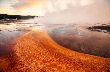 Sunset over steaming Grand Prismatic Spring in Yellowstone National Park, Wyoming, USA.