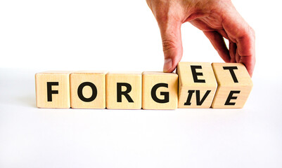 Forgive and forget symbol. Businessman turns wooden cubes and changes the word 'forgive' to...