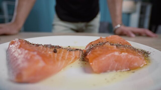 Marinated steak with salmon and the guy in the background who cooked the fish. Home cooking in the kitchen. Quickie camera move. High quality 4k footage