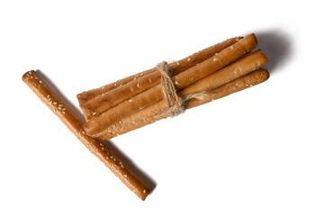 Grissini lie on a white background. Crispy white sticks. With sesame seeds. The appetizer is delicious.