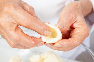 Preparation of a traditional Colombian fried  stuffed yucca dumplings called carimañolas