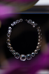 An elegant jewelry. White gold and diamonds necklace on black background.