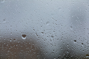 Large raindrops on the window glass. Monsoon season, rain and autumn