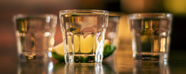 vodka shots on wooden table closeup panorama