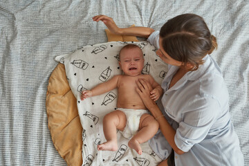 Worried mother trying to calm down crying baby