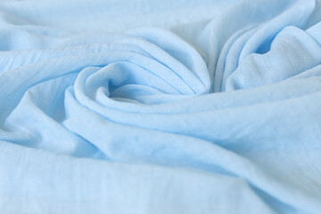 Light blue color cloth baby girl. Soft muslin baby blanket background. Cotton clothing and...
