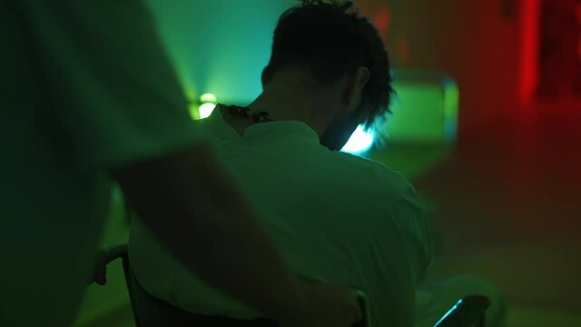 A paramedic is driving a mad male patient in wheelchair down corridor in mental hospital. Ill person in straitjacket is going crazy. Concept of paranoia or schizophrenia and madness or depression.