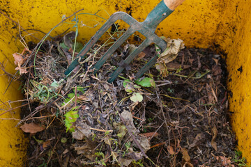 Garden fork turning backyard compost.