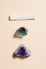 druse raw purple amethyst crystal, selenite and fluorite on beige background