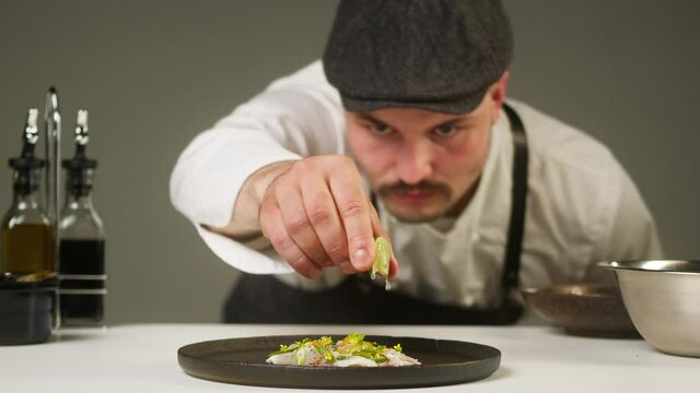 Professional Chef squeezing lime juice on peruvian ceviche on cutting board close-up. Man cooking seafood dishes using citrus fruits. Traditional Peruvian cuisine. 