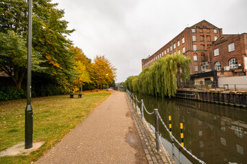 Fototapeta na wymiar Norwich, Norfolk, UK – September 11 2021. Riverside footpath along the River Wensum opposite St James housing development