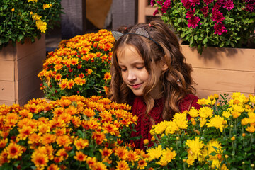 autumn portrait of a little cute girl with a plaid and flowers