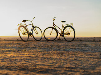 Obraz premium silhouettes of two bicycles against the sunset, romance on a summer day. High quality photo