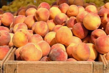 Juicy and ripe peaches in a wooden box