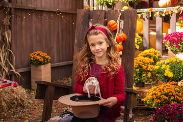 little cute girl with a hedgehog in her hands portrait in autumn