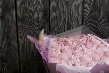 Marshmallow bouquet packed in craft paper. Zephyr rose flowers.