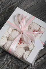 Homemade marshmallow in a gift box. Tied with a ribbon tied to a bow. On black pine boards.