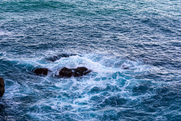 High angle view of waves crashing on rocks.