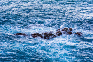 Fototapeta premium High angle view of waves crashing on rocks.