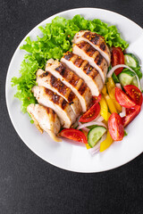 salad chicken breast meat poultry tomato, cucumber, onion, pepper, olive oil lettuce leaf mix fresh portion ready to eat meal snack on the table copy space food background rustic keto or paleo diet