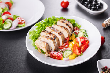 salad chicken breast meat poultry tomato, cucumber, onion, pepper, olive oil lettuce leaf mix fresh portion ready to eat meal snack on the table copy space food background rustic keto or paleo diet