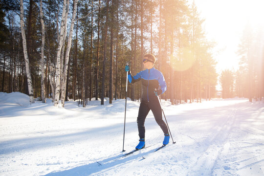 Cross country skiing, happy man skier active winter sport on snowy track, sunset background
