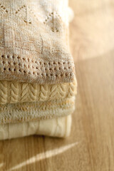 Pile of beige sweaters. Selective focus.