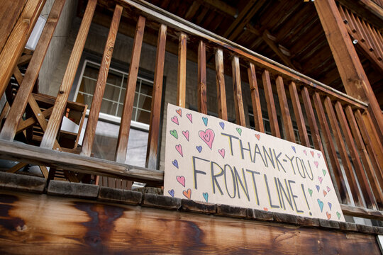 Sign with hearts thanking frontline workers on apartment balcony
