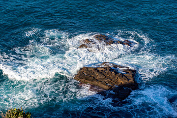 High angle view of waves crashing on rocks.