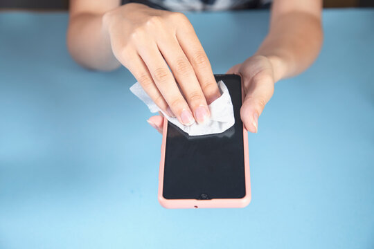 Woman Cleaning Phone In Napkin