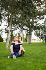 Fototapeta premium Full length image of a niece hugs her grandfather in the park on a sunny day. Outdoor portrait.