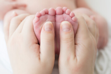 Obraz na płótnie Canvas Newborn feet in mother's hands