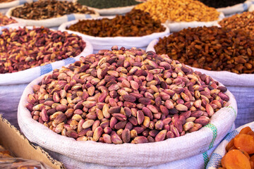 Fototapeta premium Bags with fresh pistachios and other fruits and nuts at the oriental bazaar.