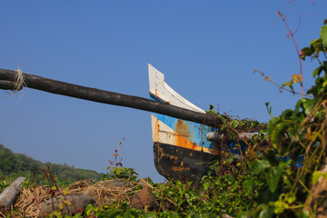 Old boat abandoned on rice fields near the coastline in Loji beach Sukabumi, Indonesia. Abandoned...