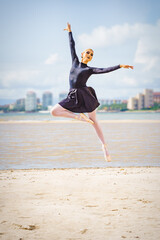 Ballet dancer doing ballet moves at the beach jumps and dance moves
