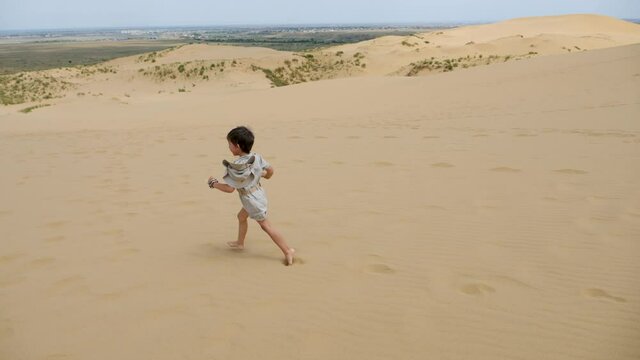 boy child runs in the clothes of a traveler with a hat runs barefoot through