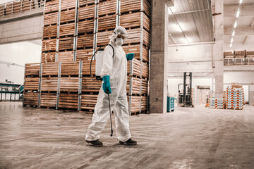 In the preventive isolated factory warehouse a dedicated expert in a special protective uniform...