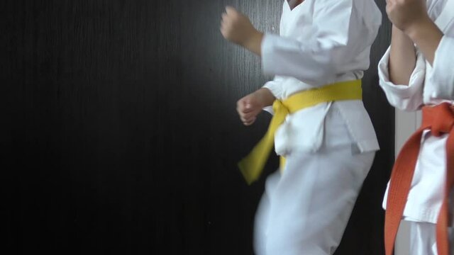 Athletes with yellow and red belts practice kicking