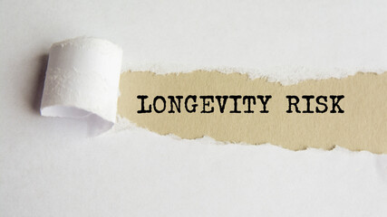 longevity risk. words. text on gray paper on torn paper background