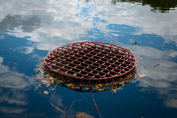 A collector for descent of water from the lake in the water is reflected in the sky with clouds