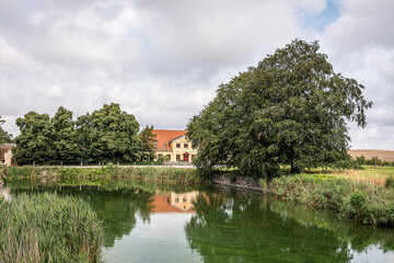 Obraz premium Yellow manour hose reflecting in the moat of Holseteinborg castle