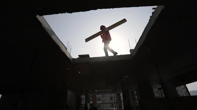 builder worker in safety protective equipment installing concrete floor slab panel at building construction site.