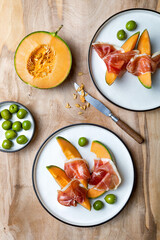 Fresh cantaloupe melon with jamon or prosciutto and green olives. Traditional Spanish and Italian...