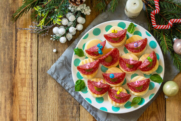 Festive snack of canapes on the Christmas table. Canapes with bread, cheese, salami and olives. Top view flat lay background. Copy space.