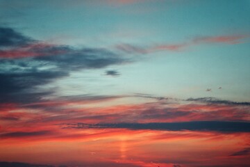 Céu Azul no Fim de Tarde com Sol Alaranjado e Nuvens Escuras