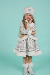 Obraz premium beautiful blonde girl with blue eyes with long hair in a snow maiden costume on a blue background new year