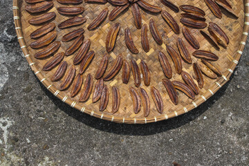 Sale pisang is an Indonesian traditional banana snack that is sliced and laid out in the sun to dry. A group of dried sliced bananas on a container called 
